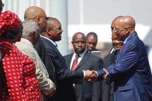 Jacob Zuma (right) arrives at the Lesotho airport and greets the man seen as main instigator of the country's crisis, Deputy Prime Minister Metsing. Prime Minister Thomas Thabane looks on, smiling from Zuma's right. (Photo: mjj)