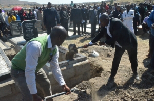 Edgar Ramahloko, right, shovels dirt onto the grave of his uncle, Mokheseng Ramahloko, the lone man killed Aug. 30. (Photo: mjj)